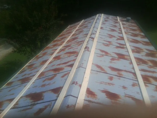 Rusted metal roof panels with new wood purlins before replacement — Storm Damage Roof Repair in Muir by Roofing Brothers