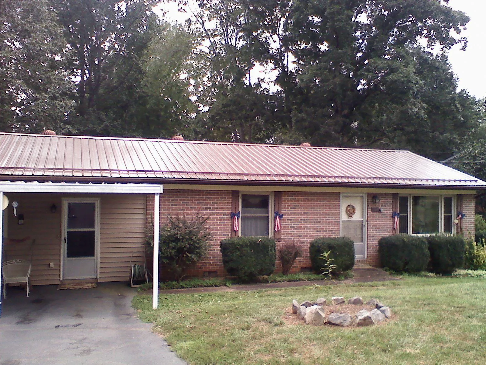 Bronze metal roof and carport on a brick ranch home — Roof Repair work by our crew in Muir